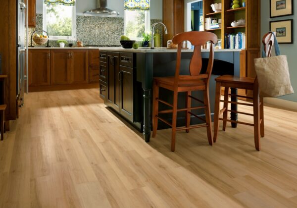 Bright kitchen featuring wooden flooring, an island, and wooden chairs
